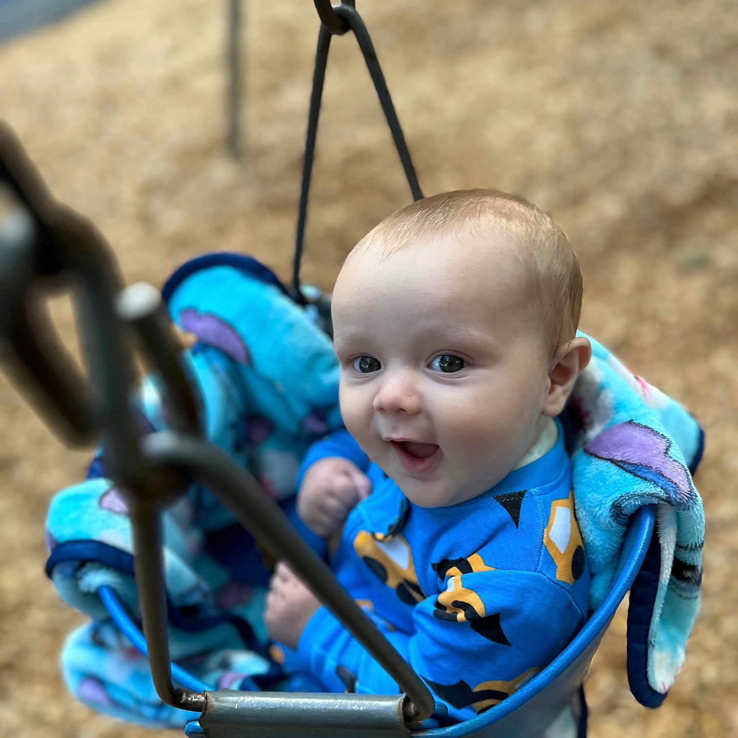 Jaimyus is registered to the contest to win money with this photo: baby, blanket, blue_clothing, child, cute, face, fun, happy, infant, metal_chain, outdoor, park, person, play, playground, seat, seat_belt, smiling, swing, young_child