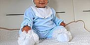 Eva participe au concours pour gagner de l'argent avec cette photo : toddler, child, blue_outfit, headband, white_socks, quilted_blanket, couch, indoor, curtains, window, sky, clouds, smile, cute, portrait, sitting, soft_lighting, baby, homedecor, person