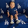 Jesse joined the competition — help win amazing prizes! baby, child, blue, clothing, sitting, blanket, logo, sportswear, footwear, socks, face, expression, indoor, cute, team_spirit, baseball, person, portrait, infant, comfortable