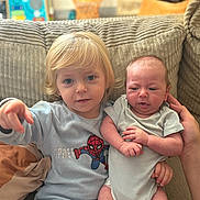 Juan a rejoint le concours — aidez-le/la à gagner de superbes lots ! child, baby, siblings, couch, indoor, spiderman, clothing, infant, toddler, person, family, cute, portrait, hand, cushion, blond_hair, expression, seated, holding, comfortable