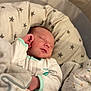 baby, sleeping, blanket, pillow, star_pattern, infant, bed, cozy, soft, newborn, cute, resting, peaceful, child, clothing, fabric, comfort, indoors, portrait, relaxation
