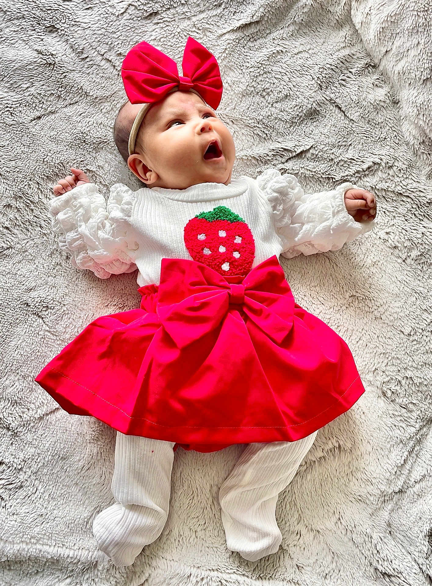 Mia is registered to the contest to win money with this photo: baby, infant, red_bow, headband, white_sleeves, red_skirt, blanket, cute, soft_texture, clothing, child, portrait, lying_down, happy, adorable, expression, fashion, small_hands, innocent, cozy