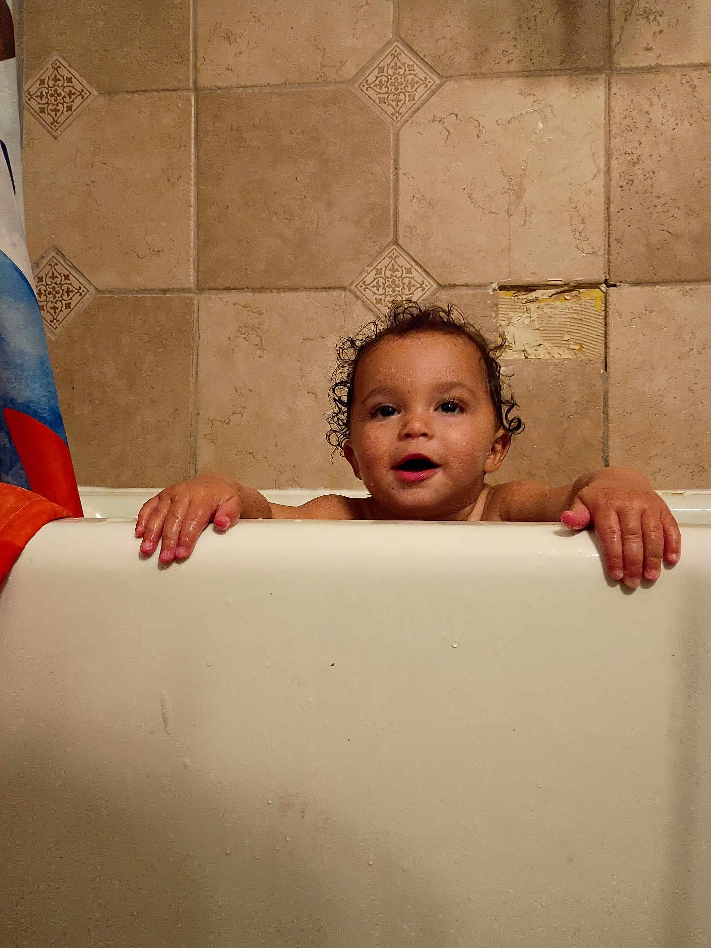Asher joined the competition — help win amazing prizes! toddler, child, bathtub, bathroom, curly_hair, tiles, hands, peeking, water_droplets, shower_curtain, happy, smiling, skin, face, indoor, young_child, playful, cute, baby, person