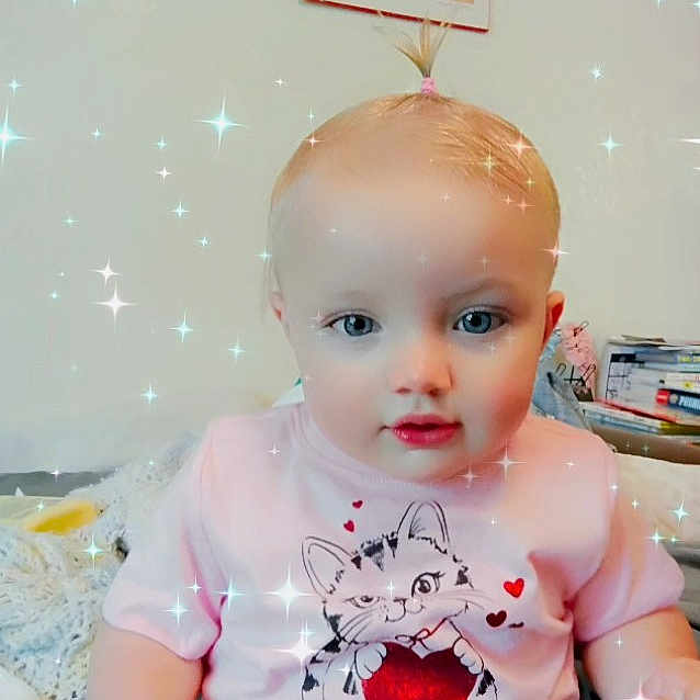 Emily joined the competition — help win amazing prizes! baby, child, indoor, pink_shirt, cartoon_cat, heart, pony_tail, sparkles, cute, portrait, seated, toy, furniture, face, eyes, hands, expression, clothing, young_child, home