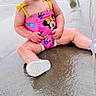 toddler, child, swimsuit, pink, minnie_mouse, sitting, water, wet_surface, play_area, outdoor, smiling, happy, barefoot, summer, fun, young_child, play, cute, water_splash, daytime