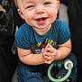 baby, child, smiling, stroller, blue_shirt, jeans, boots, hands, face, happy, cute, toy, socks, indoor, portrait, infant, person, clothing, footwear, expression