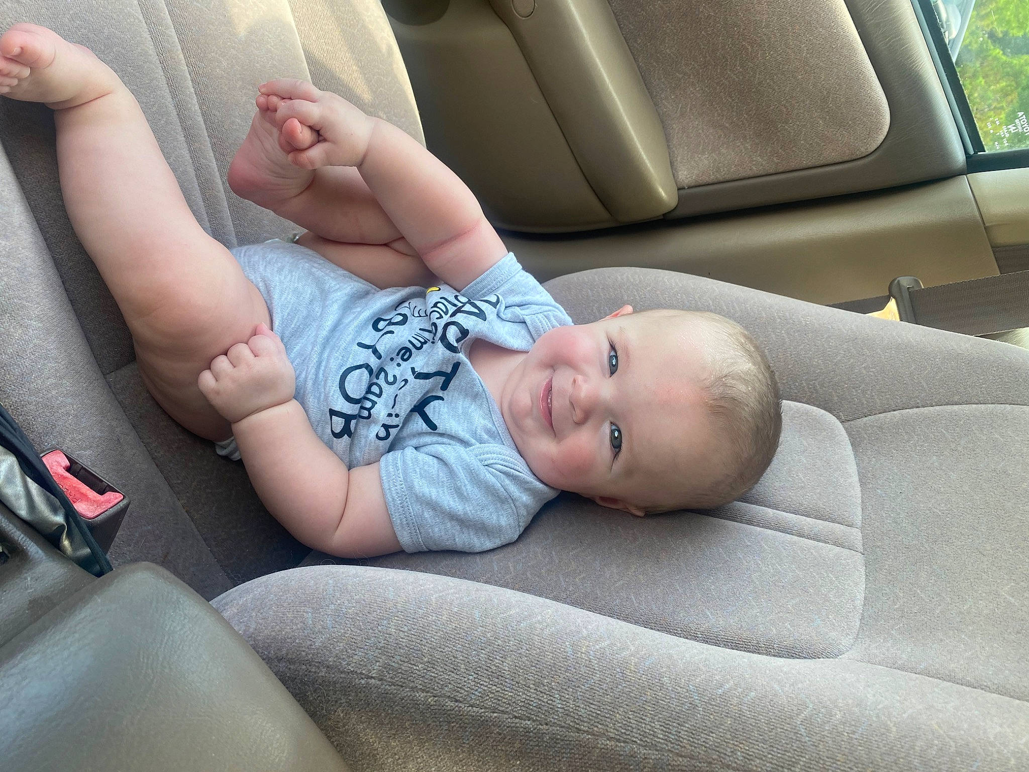 Jaxon is registered to the contest to win money with this photo: auto_part, automotive_design, automotive_exterior, baby, car, car_seat, car_seat_cover, comfort, head_restraint, joy, knee, motor_vehicle, person, personal_luxury_car, plant, seat_belt, steering_part, thigh, toddler, vehicle