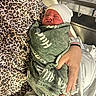 baby, bed, blanket, care, closeup, hands, hospital, hospital_bassinet, indoor, infant, leopard_print, maternity, newborn, parent, person, resting, sleeping, swaddled, white_hat, wristband