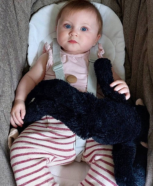 Gaïa participe au concours pour gagner de l'argent avec cette photo : arm, baby, baby_toddler_clothing, black, chair, cheek, comfort, doll, eyelash, finger, grey, hand, leg, nail, neck, person, pink, skin, sleeve, sock