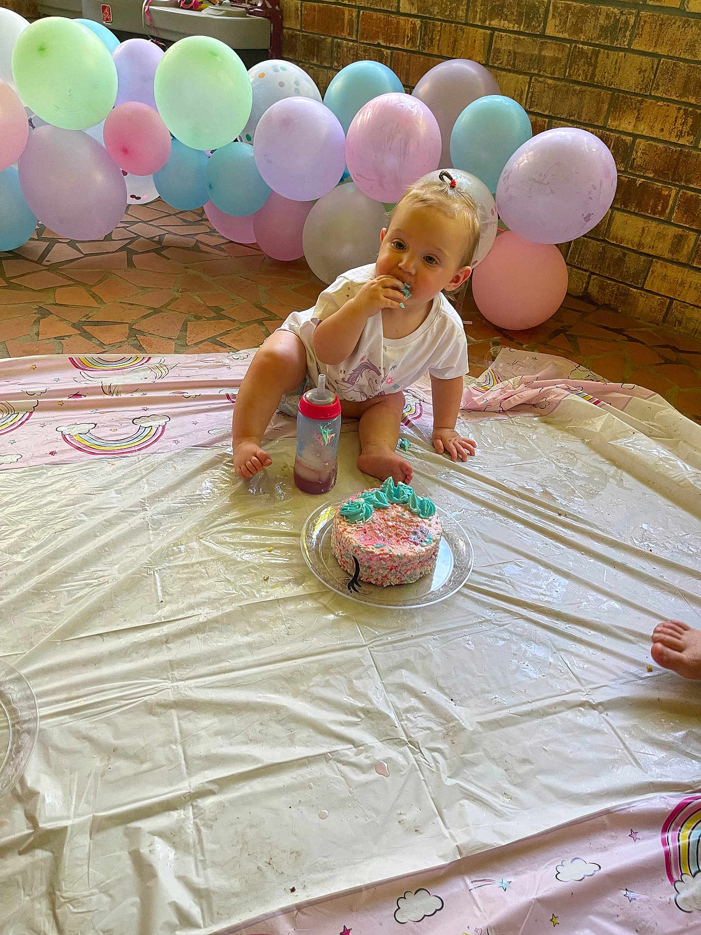 River joined the competition — help win amazing prizes! toddler, cake, balloons, birthday, party, plastic_cover, floor, sippy_cup, blue_frosting, rainbow_pattern, brick_wall, indoor, messy, celebration, child, food, sitting, clothing, cute, small_person
