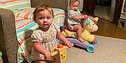 Willow joined the competition — help win amazing prizes! toddler, baby, toy, unicorn_toy, ride_on_toy, carpet, living_room, door, chair, striped_blanket, person, floor, wood_floor, child, indoor, play, furniture, curious, happy, casual