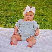 Willow is registered to the contest to win money with this photo: baby, infant, child, headband, bow, grass, outdoor, blanket, greenery, nature, cute, sitting, portrait, daylight, soft_clothing, chubby, skin, face, young_child, serene