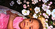 Yaleia joined the competition — help win amazing prizes! baby, infant, child, pink_clothing, flower, blossom, spring, nature, outdoor, floral, cushion, portrait, cute, peaceful, garden, face, skin, head, eyes, lying_down