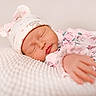 baby, sleeping, hat, bunny_ears, floral_outfit, blanket, closeup, peaceful, infant, cute, soft_texture, hand, portrait, newborn, resting, pink, white, cozy, child, adorable
