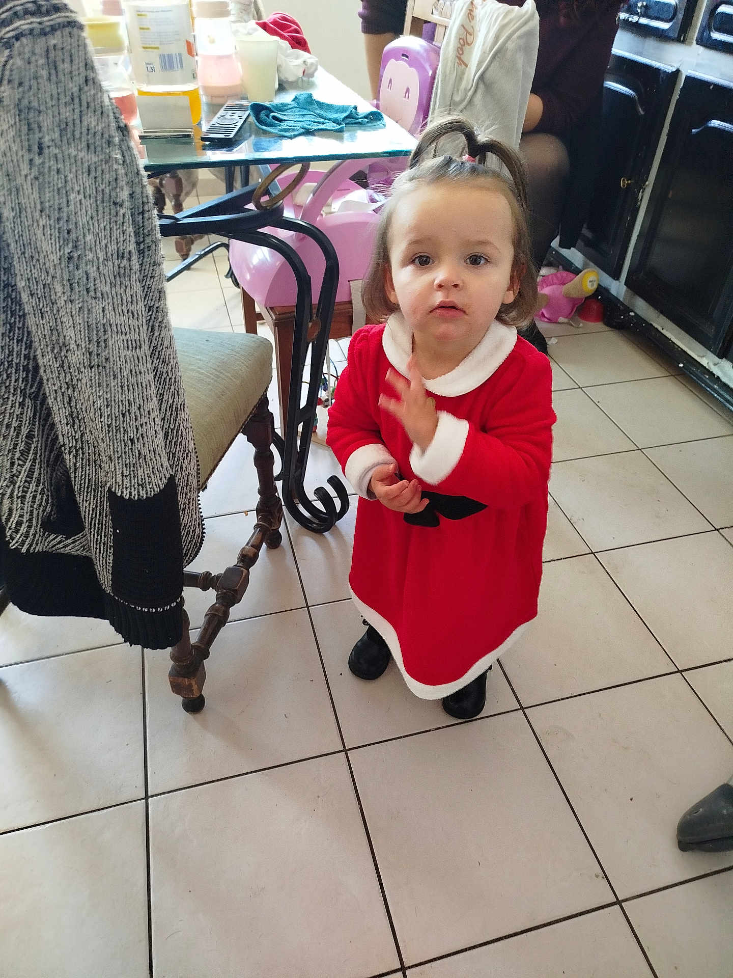 Elyna participe au concours pour gagner de l'argent avec cette photo : toddler, child, red_dress, indoor, tile_floor, table, chair, person, furniture, curious, young_child, black_shoes, kitchen, home, clothing, hair_tie, standing, looking, floor, casual