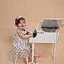 Josephine is registered to the contest to win money with this photo: toddler, child, dress, polka_dot, white_piano, small_stool, birthday, one, letters, happy, smiling, playing, musical_instrument, studio, indoor, cute, headband, barefoot, light_background, portrait