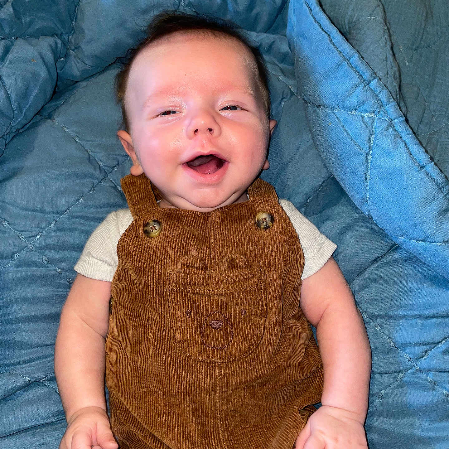 Klaysen is registered to the contest to win money with this photo: baby, babylaughing, bed, clothing, coat, couch, dress, face, furniture, happy, head, jacket, jeans, laughing, pants, person, photography, portrait, quilt, smile