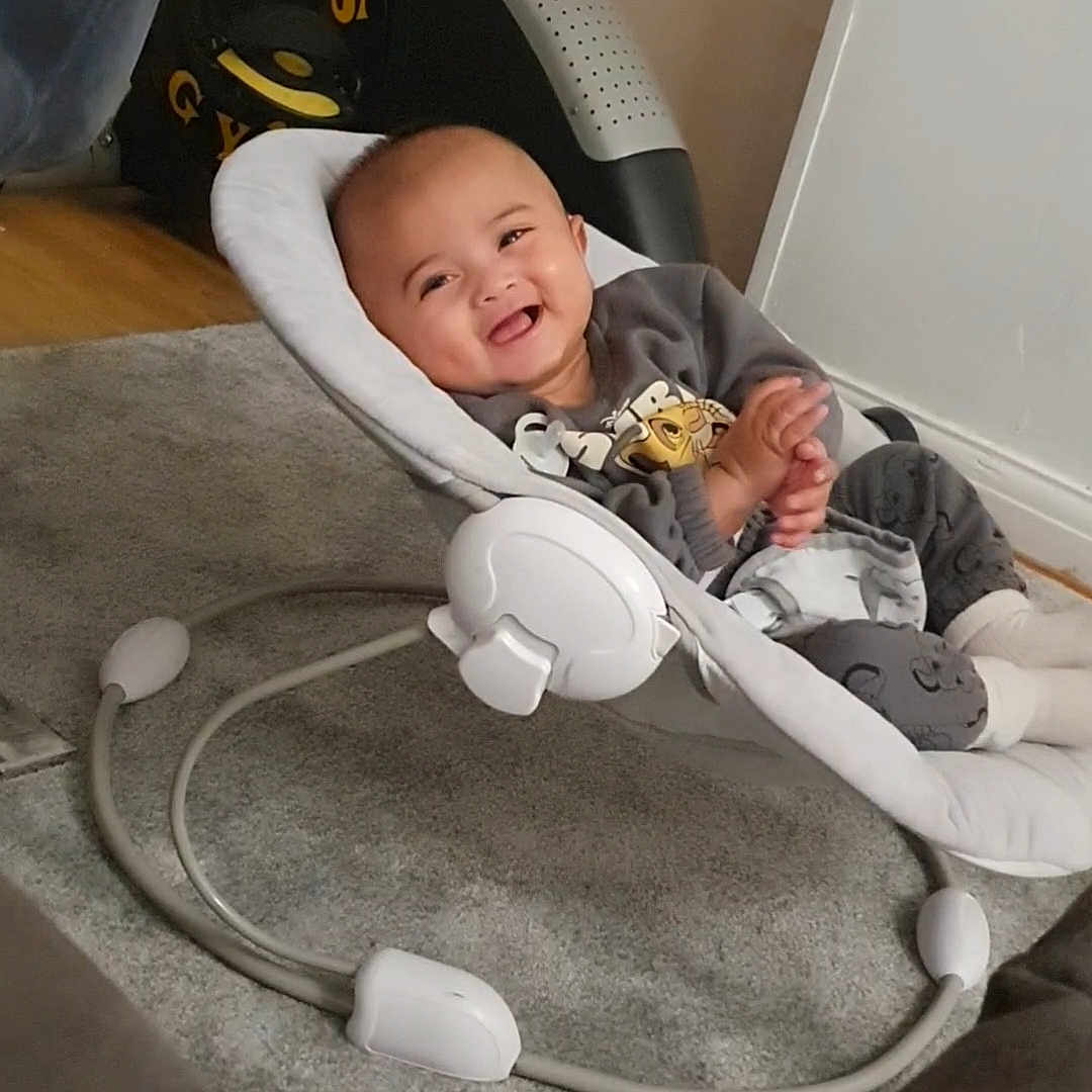 Iden joined the competition — help win amazing prizes! baby, baby_rocker, carpet, child, clapping, clothing, cozy, cute, expression, footwear, furniture, happy, home, indoor, infant, person, relaxing, seat, smiling, toy