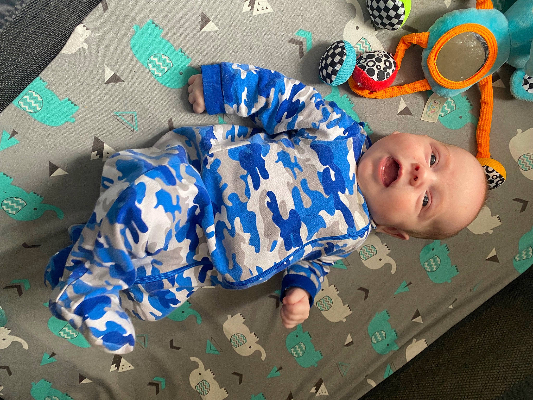 Taten is registered to the contest to win money with this photo: art, baby, baby_products, baby_toddler_clothing, baby_toys, child, comfort, electric_blue, fashion_accessory, happy, linens, pattern, person, plastic, room, sleeve, textile, toddler