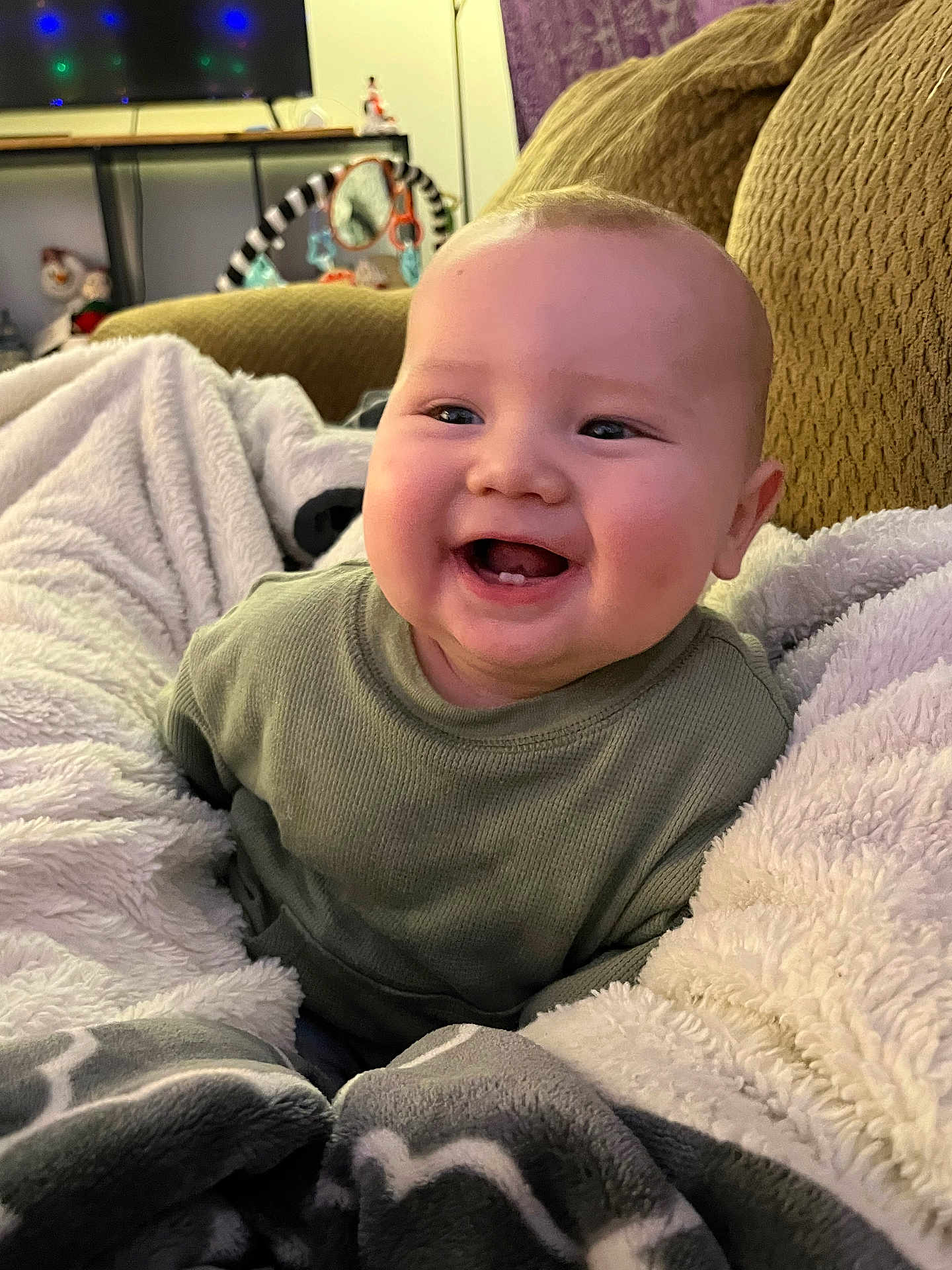 Floyd joined the competition — help win amazing prizes! baby, infant, child, smile, teeth, blanket, couch, cozy, portrait, close_up, chubby_cheeks, happy, living_room, toy, playmat, television, plush, clothing, sitting, home
