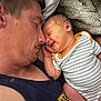 Floyd is registered to the contest to win money with this photo: baby, newborn, adult_male, sleeping, smiling, cuddling, onesie, striped_clothing, blanket, pillow, closeup, portrait, cozy, tenderness, skin, cheek, arm, love, bedtime, indoor