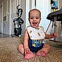 Christopher is registered to the contest to win money with this photo: baby, child, smile, sitting, carpet, bib, teddy_bear_pattern, vacuum_cleaner, baby_toy, indoor, foot, hand, clothing, person, head, face, happy, room, home, floor
