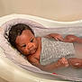 baby, infant, bathtub, water, bath, child, curly_hair, skin, face, hand, relaxing, indoor, bathroom, toddler, young_child, comfort, soaking, gray_cloth, seat, calm