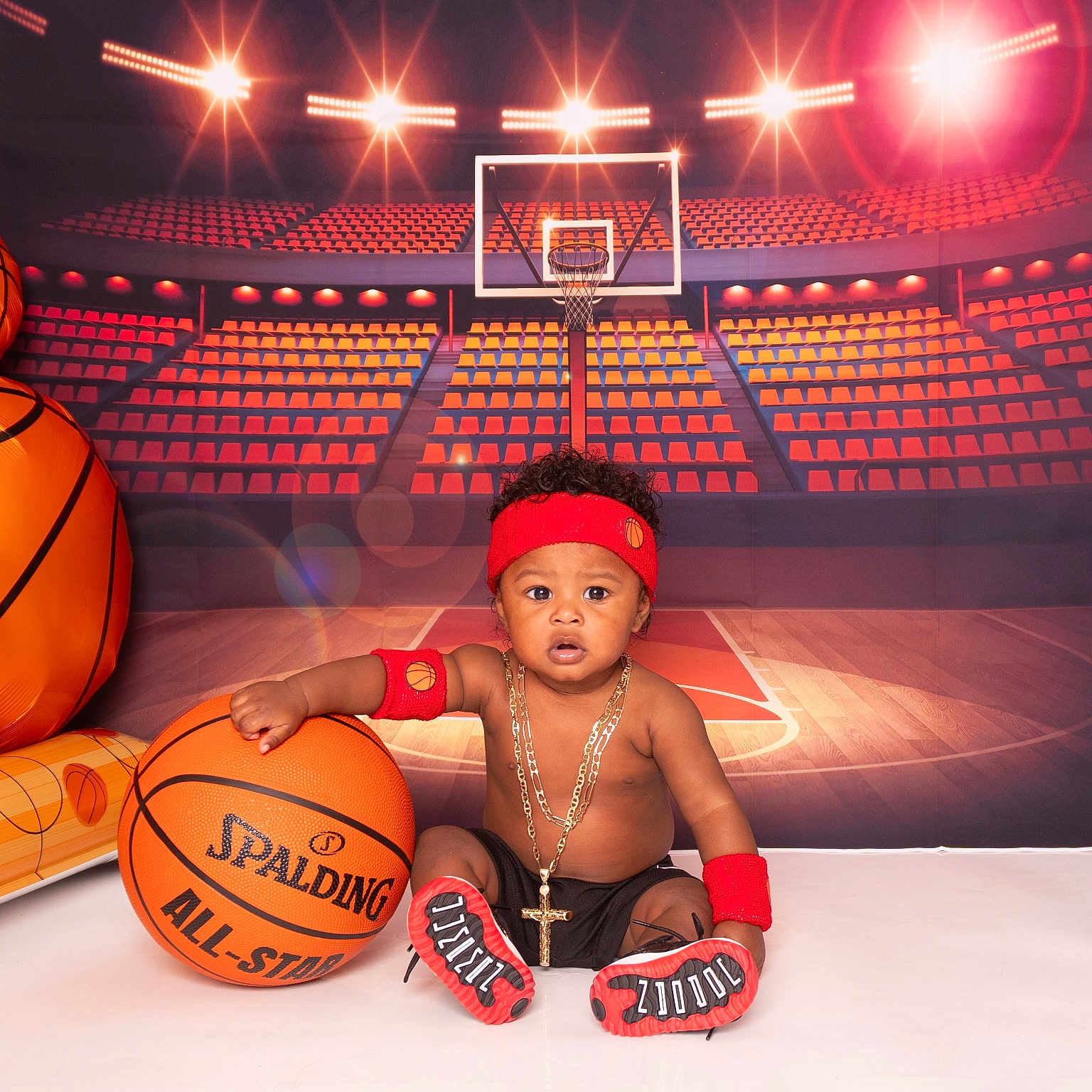 Akeem is registered to the contest to win money with this photo: baby, basketball, sportswear, headband, wristband, sneakers, court, indoor, child, portrait, toy, ball, seated, cute, accessories, background, red, black, gold, playful