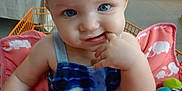 Freya is registered to the contest to win money with this photo: baby, child, blue_eyes, finger_in_mouth, baby_seat, elephant_print, colorful, curious, close_up, indoor, infant, cute, soft_skin, portrait, clothing, sleeveless, pink, blue, toy, expression