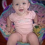 baby, child, infant, onesie, pink_clothing, teether, baby_chair, patterned_fabric, happy, smiling, indoor, wood_floor, person, bare_feet, toy, seated, cute, face, small_child, comfort