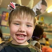 Zane joined the competition — help win amazing prizes! child, smiling, headband, cow_ears, flower, teeth, classroom, indoor, happy, boy, short_hair, camouflage_shirt, playful, cute, portrait, people, background_blur, kids, fun, education
