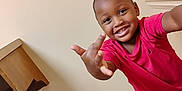 Xion joined the competition — help win amazing prizes! child, smiling, red_shirt, indoor, wood_floor, beige_wall, playful, person, happy, young, casual_clothing, portrait, boy, hand_gesture, home, floor, sleeve, short_hair, light, room