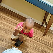 Xion joined the competition — help win amazing prizes! child, boy, indoor, wooden_floor, table, crouching, casual_clothing, red_shirt, beige_shorts, footwear, playful, motion_blur, person, home, flooring, furniture, kid, expression, portrait, young