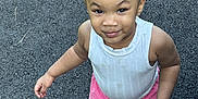 Ava joined the competition — help win amazing prizes! toddler, child, girl, standing, outdoor, asphalt, pink_shorts, white_top, crocs, hairstyle, bun, smile, playful, casual_clothing, feet, person, skin, young_child, summer_clothing, expression