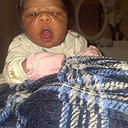 Stella Aïcha a rejoint le concours — aidez-le/la à gagner de superbes lots ! baby, blanket, child, cozy, face, furniture, handwear, indoor, infant, mirror, mittens, mouth_open, newborn, person, plaid, portrait, sleepwear, soft, warm, young