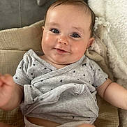 Alessyo participe au concours pour gagner de l'argent avec cette photo : baby, infant, smile, face, eyes, onesie, diaper, blanket, cute, child, skin, arm, hand, head, comfort, lying_down, expression, indoor, clothing, young