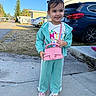 Jheselyn is registered to the contest to win money with this photo: blue_suv, car, casual_clothing, child, cute, daylight, girl, happy, outdoor, person, pink_purse, playful, residential_area, sidewalk, smile, sneakers, standing, sunny, tracksuit, young_child
