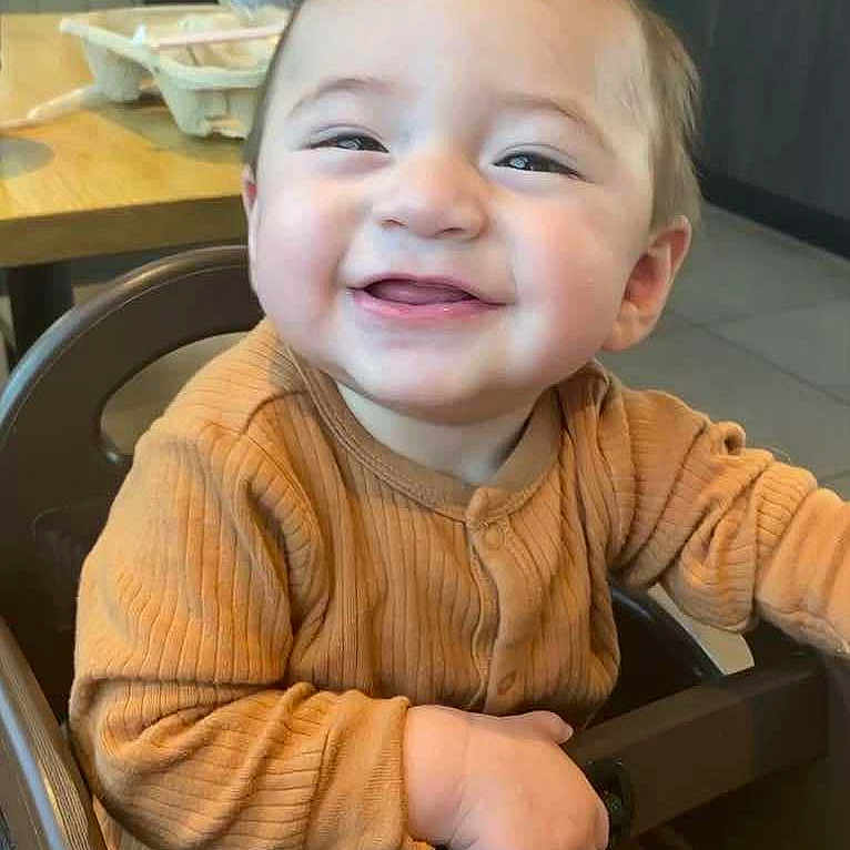 Elijah is registered to the contest to win money with this photo: accessories, baby, boy, chair, child, clothing, cutlery, face, furniture, happy, head, indoors, laughing, male, person, photography, portrait, smile, spoon, table
