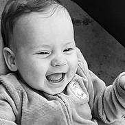 Mila participe au concours pour gagner de l'argent avec cette photo : baby, smiling, happy, face, child, jacket, clothing, portrait, closeup, cute, infant, joy, texture, black_and_white, hands, expressive, young, warm, emotion, candid
