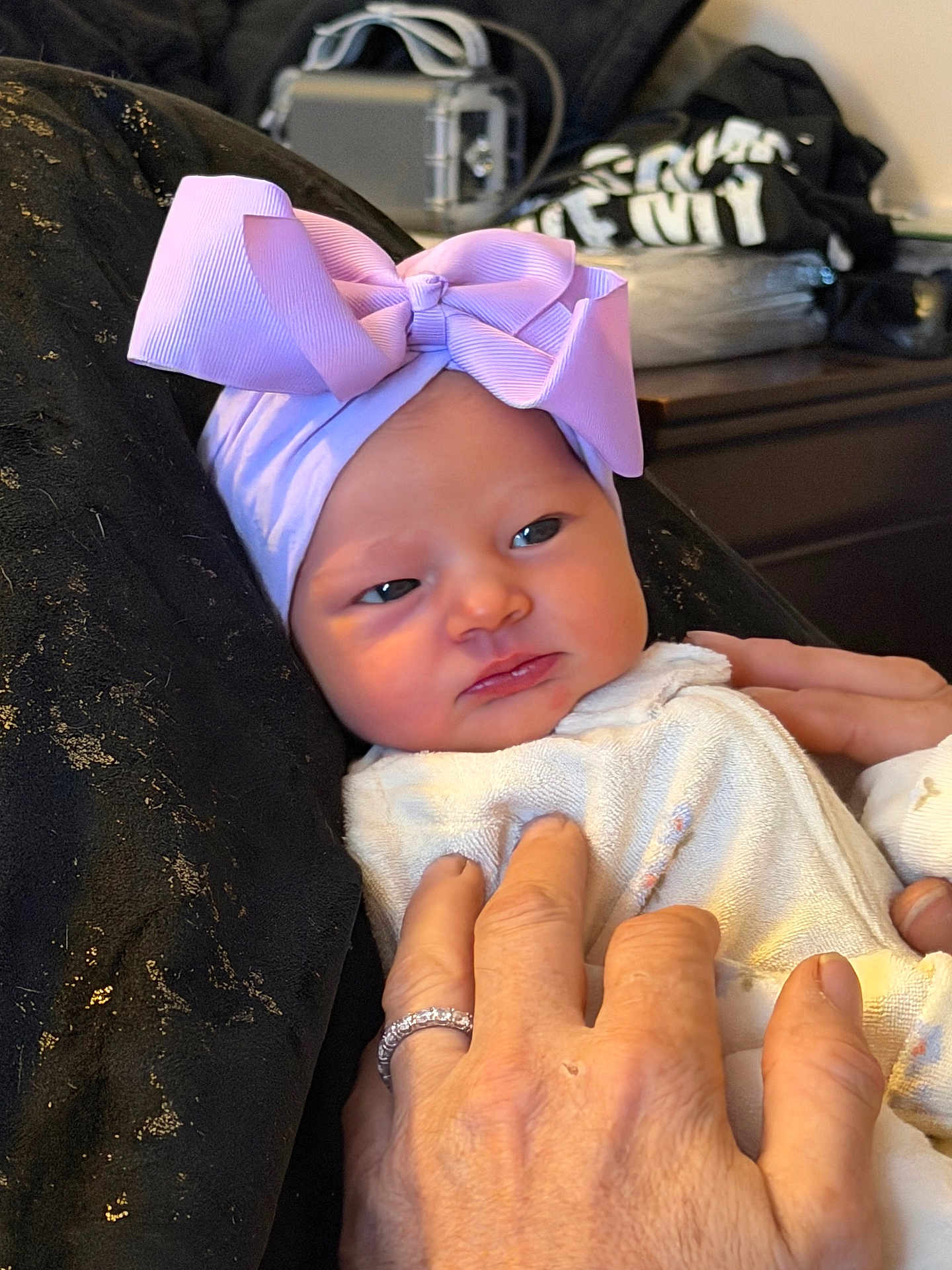 Delaine joined the competition — help win amazing prizes! baby, infant, bow, headwear, hand, ring, clothing, person, portrait, face, skin, fingers, bedroom, blanket, cozy, indoor, expression, newborn, soft, gentle