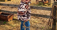 Jose Maria is registered to the contest to win money with this photo: child, cowboy_hat, rope, horse, barn, hay, fence, boots, jeans, jacket, farm, animal, outdoor, rural, pet, grass, dirt, playful, portrait, sunset