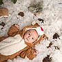 baby, infant, reindeer_costume, costume, pinecones, pine_branches, fluffy, snow_like, winter, holiday_theme, cute, lying_down, soft_texture, christmas, festive, nature_elements, small_tree, warm_clothing, indoor, portrait