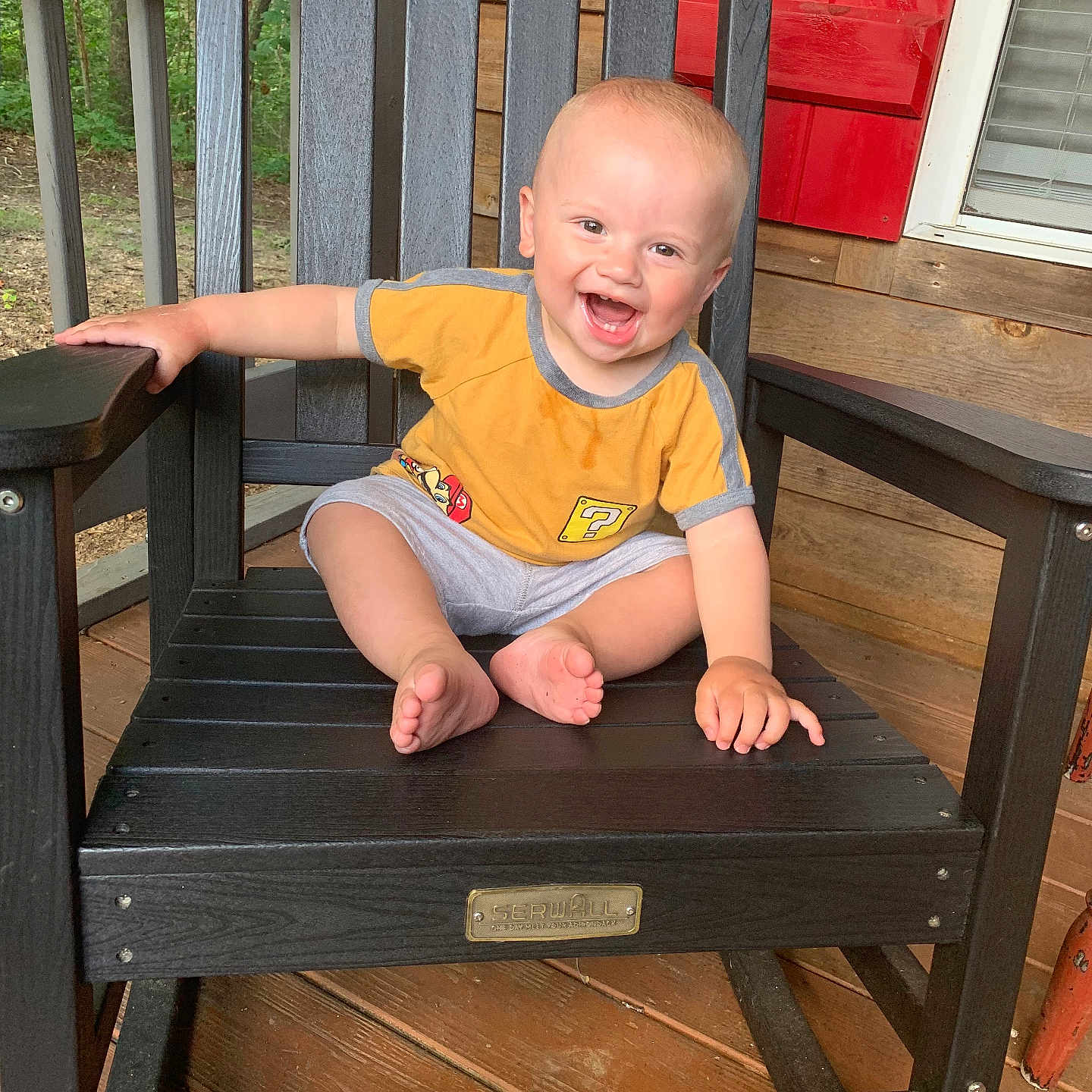 Vincent joined the competition — help win amazing prizes! baby, barefoot, casual, child, face, gray_shorts, hand, happy, outdoor, person, planks, porch, rocking_chair, seat, sitting, smiling, toddler, wood, wooden_chair, yellow_shirt