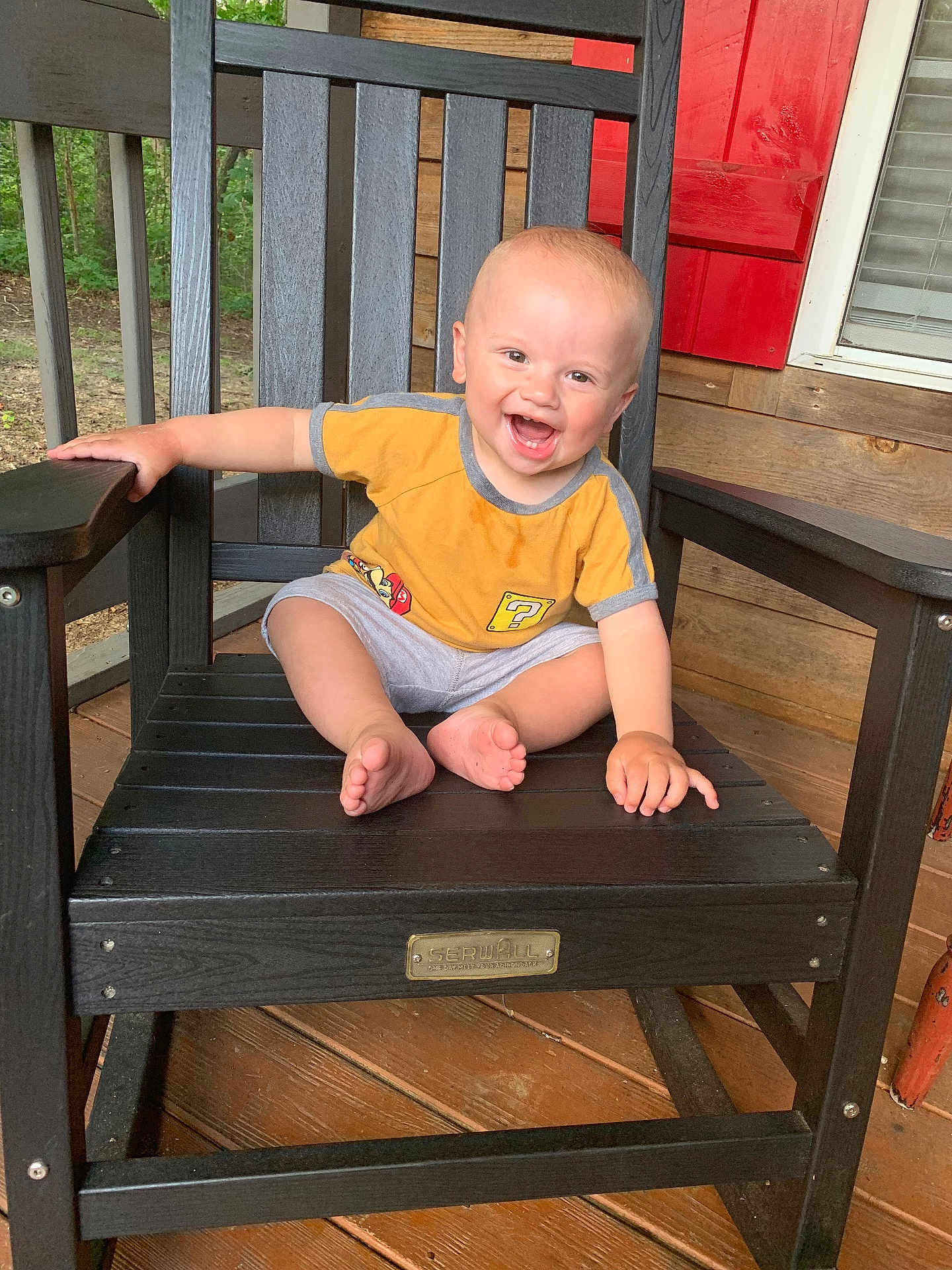 Vincent joined the competition — help win amazing prizes! toddler, child, smiling, yellow_shirt, gray_shorts, rocking_chair, wooden_chair, porch, outdoor, happy, barefoot, baby, seat, wood, planks, hand, face, person, sitting, casual