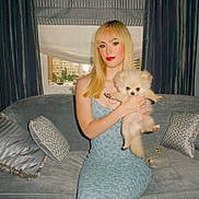 Boo joined the competition — help win amazing prizes! blonde_hair, blue_dress, cityscape, couch, curtain, dog, dress, face, fashion, fur, indoor, pet, pillow, pomeranian, portrait, puppy, sitting, smile, window, woman