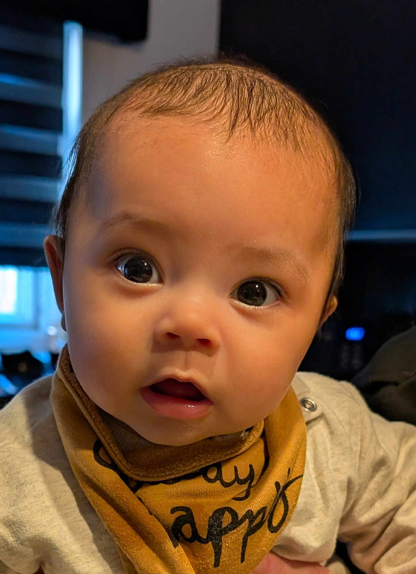 Sheridan is registered to the contest to win money with this photo: baby, infant, face, eyes, mouth, bib, clothing, curious, closeup, portrait, child, indoors, expression, skin, head, person, cute, young, human, adorable