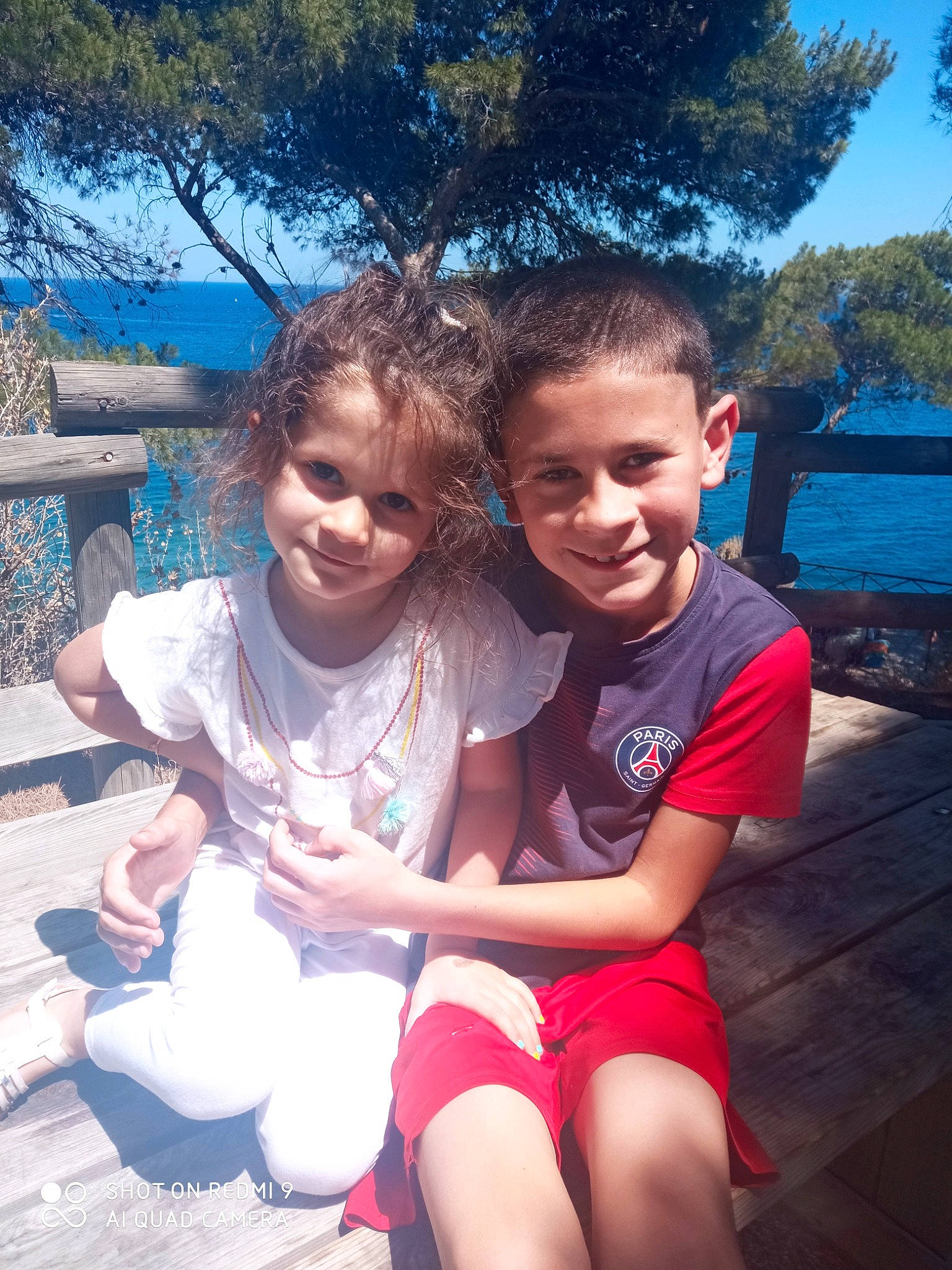 Lola participe au concours pour gagner de l'argent avec cette photo : blue, child, event, face, fun, grass, hair, happy, human_leg, joy, leisure, mammal, person, recreation, shorts, sitting, sky, smile, summer, thigh