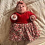 Ambre participe au concours pour gagner de l'argent avec cette photo : baby, infant, child, red_sweater, floral_skirt, headband, bedspread, patterned_bedspread, lying_down, cute_expression, puckered_lips, small_hands, white_socks, indoors, soft_lighting, portrait, young_child, clothing, fabric, person