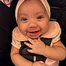 baby, infant, smiling, headband, pink_clothing, car_seat, harness, child, cute, happy, portrait, closeup, baby_girl, baby_face, hand, seatbelt, infant_clothing, baby_accessory, child_in_car_seat, adorable