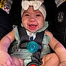 baby, smiling, car_seat, headband, pacifier, child, infant, safety_harness, clothing, green_outfit, happy, cute, seatbelt, warning_label, black_background, closeup, person, infant_fashion, portrait, child_safety